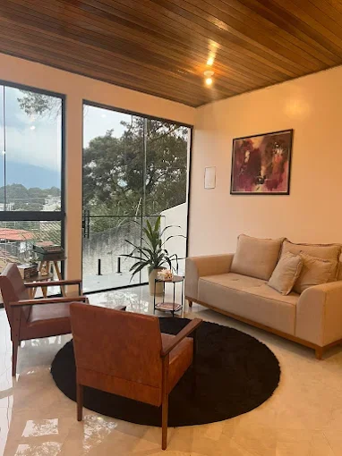 Sala de espera do consultório de Thamires Lopes em Atibaia - SP, ambiente acolhedor com poltronas e sofá